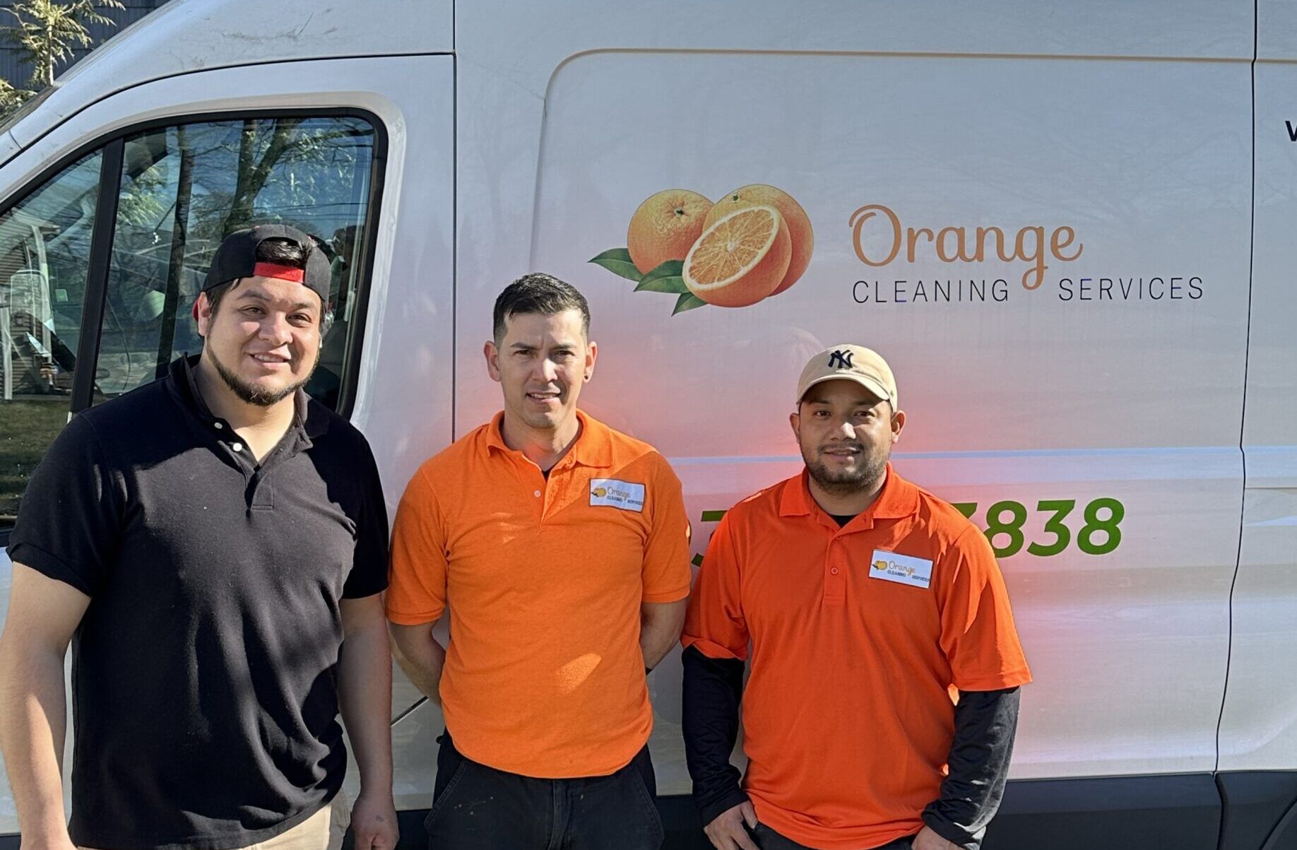 Three workers standing in front of a white service van.